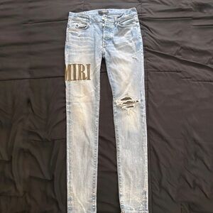 AMIRI Light Blue Distressed Jeans with Black Logo